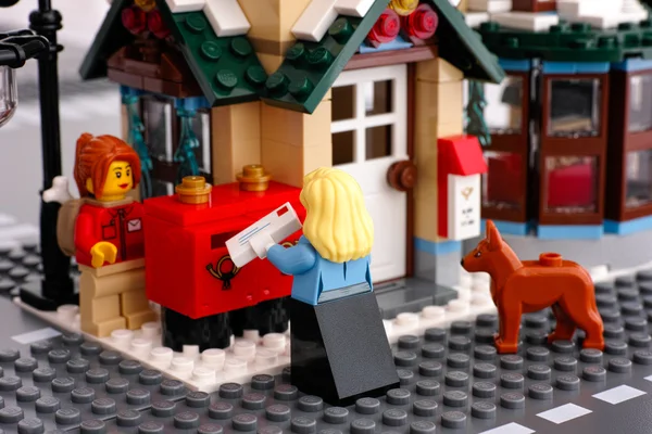 Lego post office. Woman with letter near post boxes.