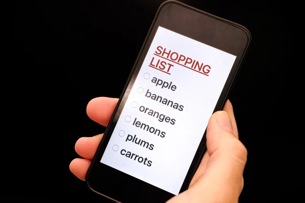 Shopping List on smart phone display in woman hand
