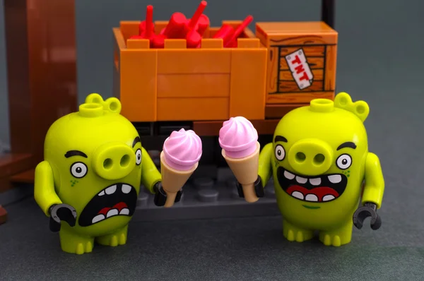 Two bad piggies with ice cream stands near box with dynamite