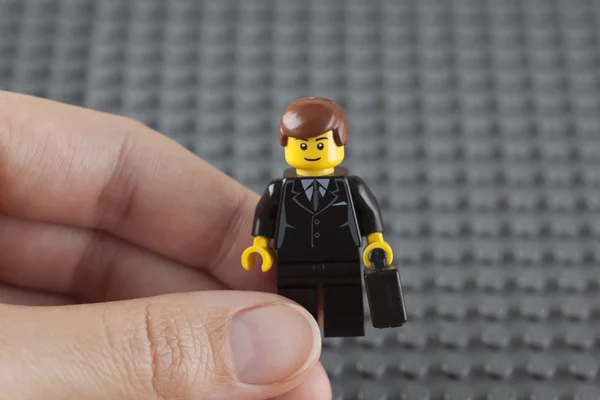 Lego businessman in human hand