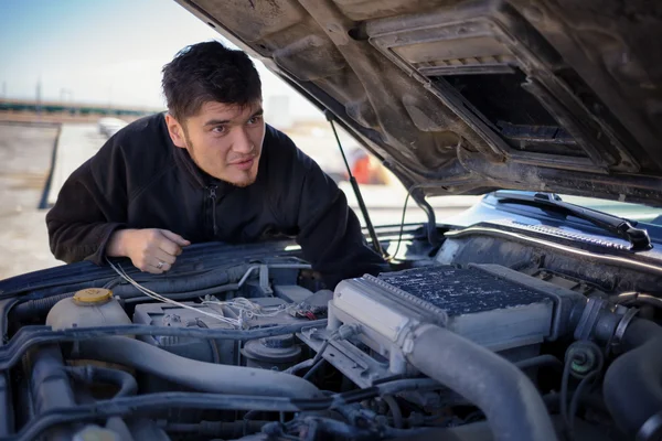 Guy looking broken down car