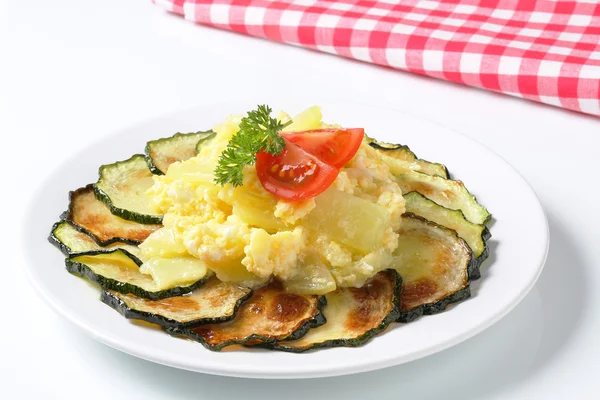 Circle of roasted zucchini slices with potatoes and fried eggs