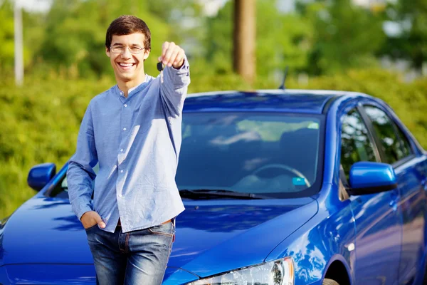 Young man holding key of his new car