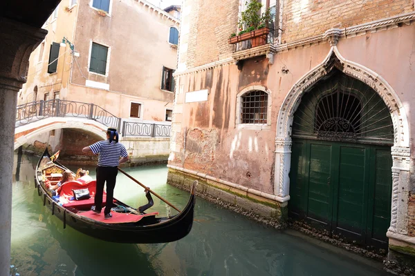 Gondola with gondolier and tourists