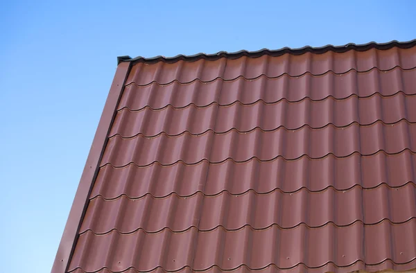 House roof from brown metal tile closeup