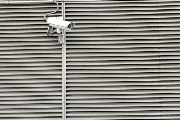 Security camera on a building stripe wall