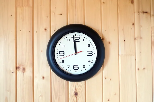 Big round wall clock on wooden background