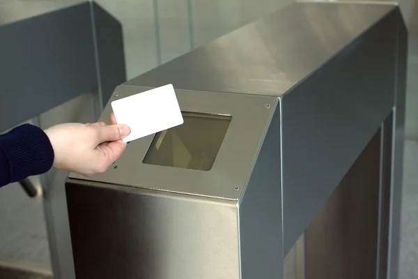 Woman's hand puts white access card to reader closeup
