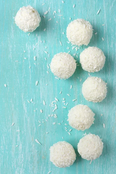 Coconut candies on aquamarine wood