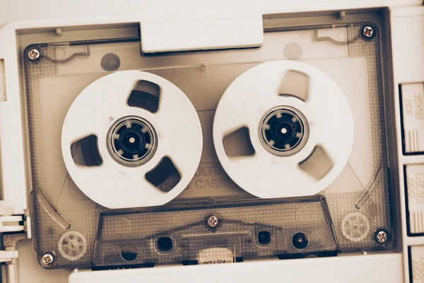 Rewinding of vintage audio tape compact cassette, sepia tone with artistic film noise