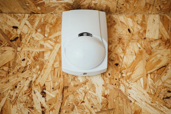 Motion detector (sensor) in action, osb wall background