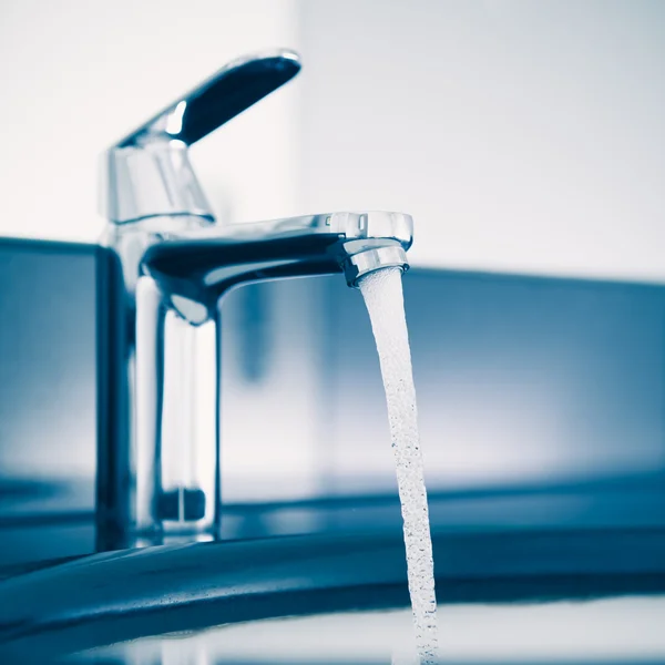 Faucet with flowing water, blue tone