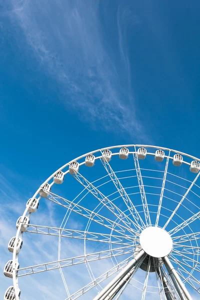 White ferris wheel against blue sky background