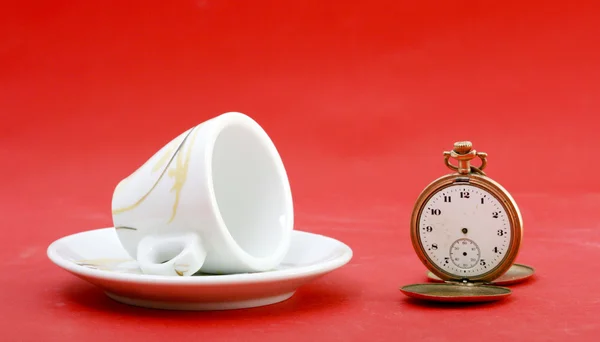Coffee pot and vintage pocket watch on a red background. Coffee break time