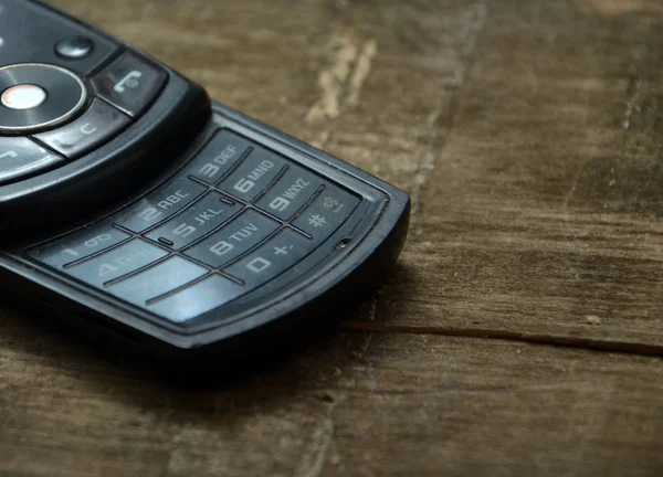 Old mobile phone on a wooden background