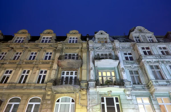 Facades of tenement houses with balconies during the night in Poznan