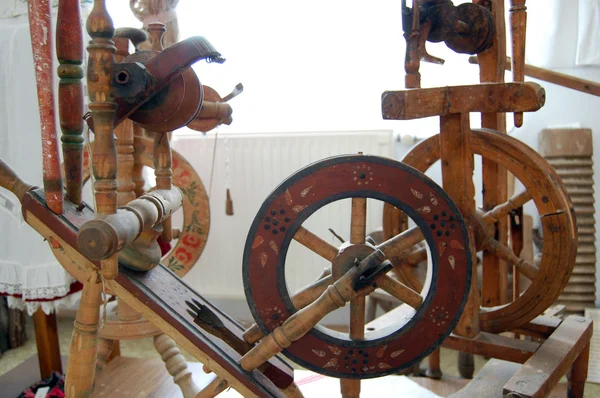 antique wooden spinning wheel with yarn and bobbins