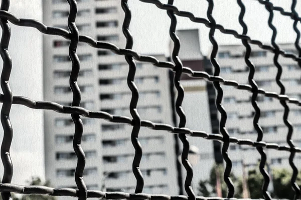 Looking through the chain-link fence on a high-rise estate