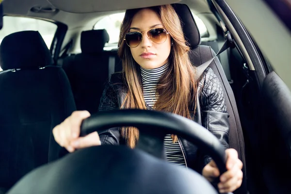 Beautiful young woman driving her car.