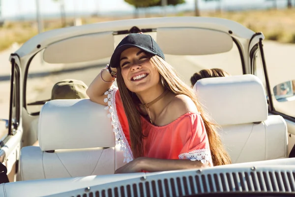 Pretty young woman driving on road trip on beautiful summer day.