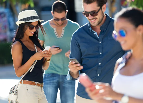 Portrait of group of friends having fun with smartphones.