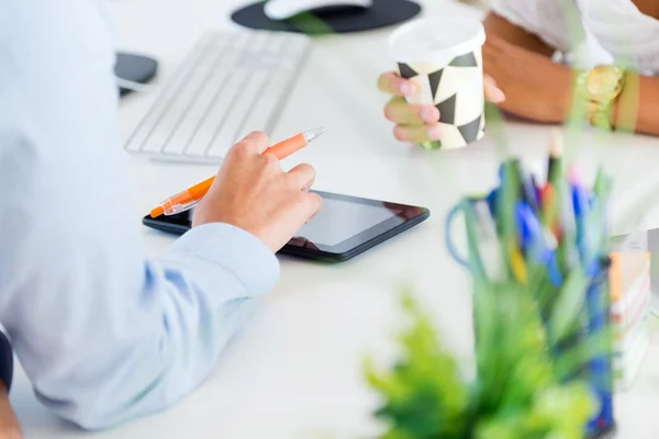 Two business woman working in office with digital tablet.