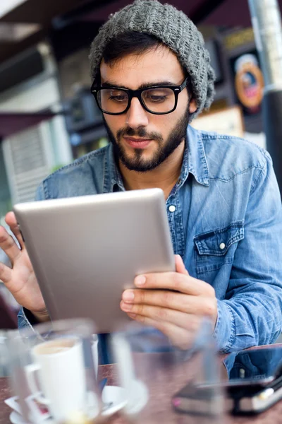 Modern young man with digital tablet in the street.