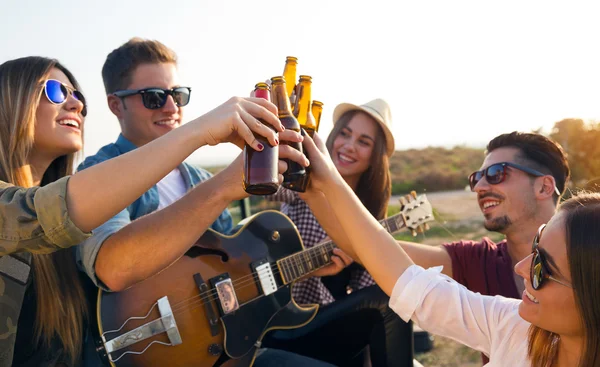 Portrait of group of friends toasting with bottles of beer.