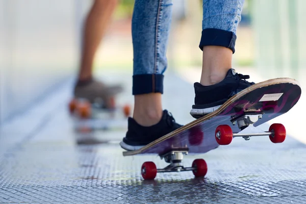 Young couple skateboarding in the street.