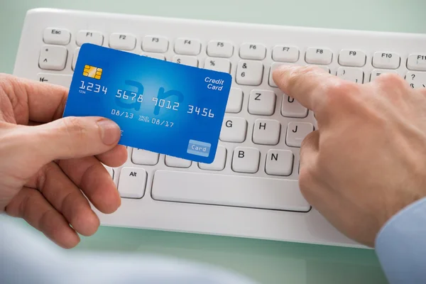 Hands with credit Card over Keyboard