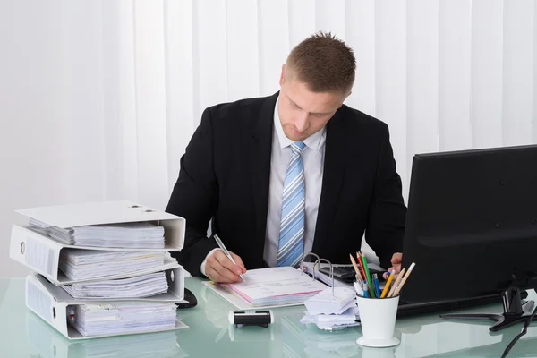 Businessman Calculating Tax in Office