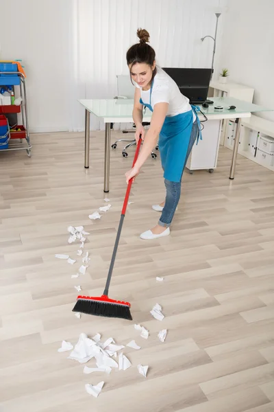 Female Janitor Sweeping Hardwood Floor