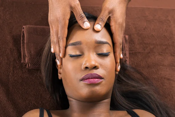Woman Receiving Forehead Massage In Spa