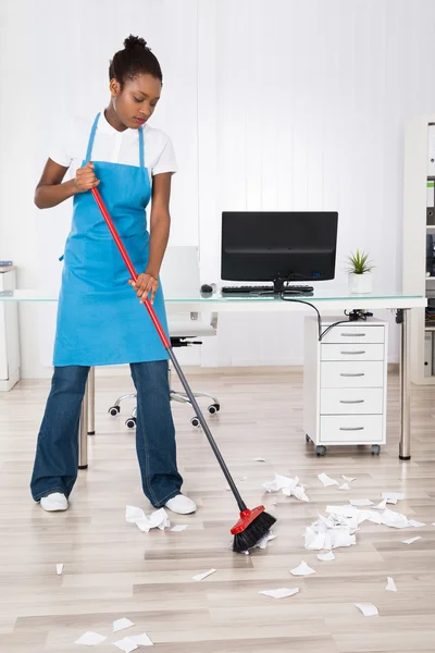Female Janitor Sweeping Hardwood Floor
