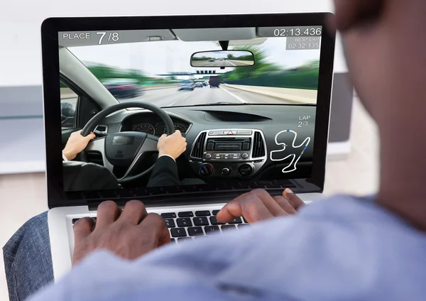 Man Playing Car Game On Laptop