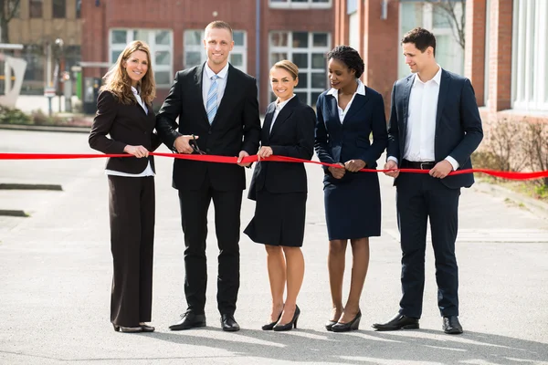 Businesspeople Cutting Ribbon