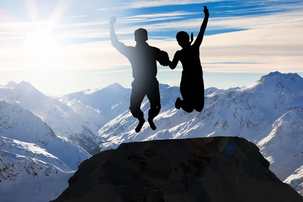 Couple Jumping Together in Mountains