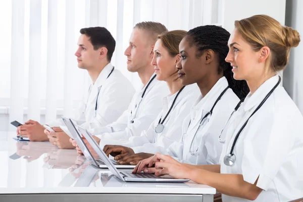 Doctors Using Laptops In Meeting