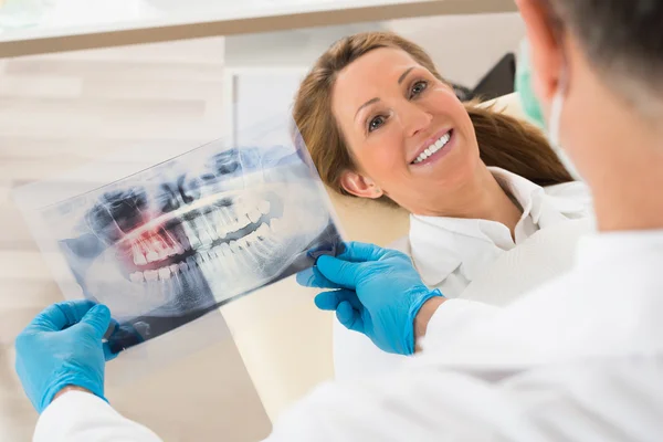 Dentist With Teeth X-ray In Front Of Woman