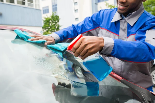Male Worker Cleaning Car Windshield