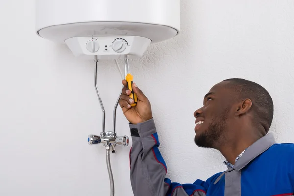 Worker Fixing Electric Boiler With Screwdriver