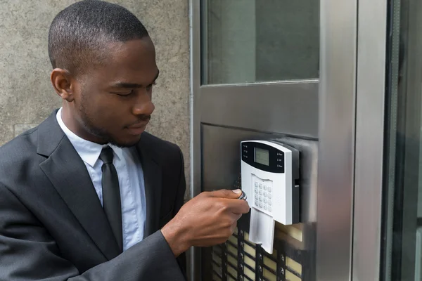 Businessman Entering Code In Security System