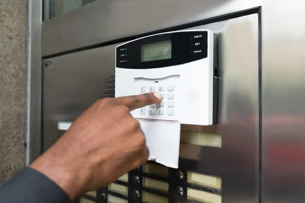 Businessperson Entering Code In Security System