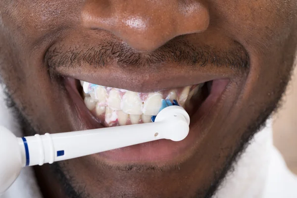 Close-up Of An African Man Cleaning His Teeth