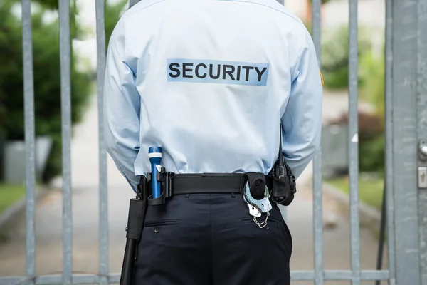 Security Guard Standing In Front Of Gate