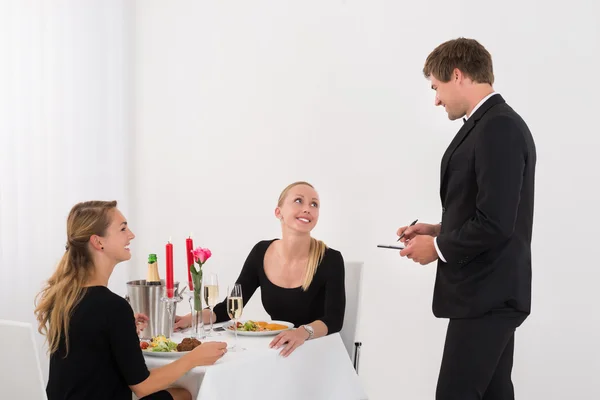 Waiter Taking An Order From Female Friends