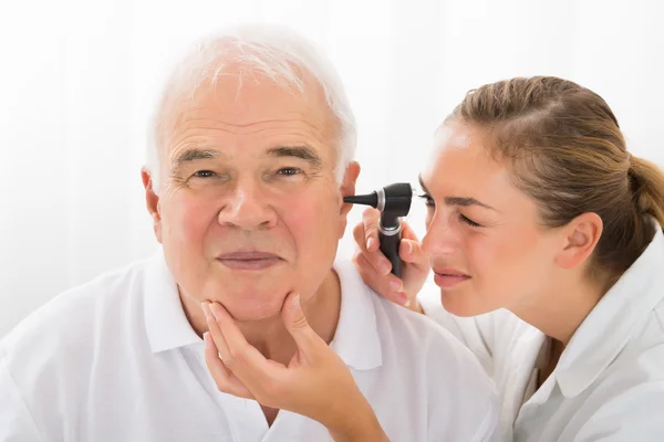 Doctor Looking At Patient\'s Ear Through Otoscope