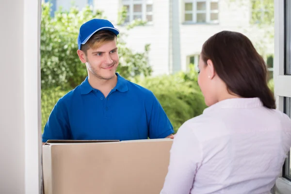 Woman Receiving Package From Delivery Man