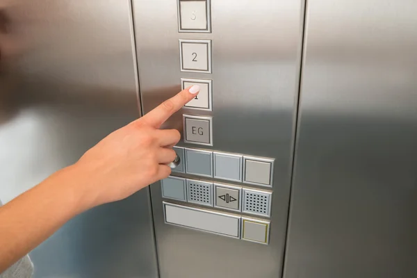 Hand Pressing First Floor Button In Elevator