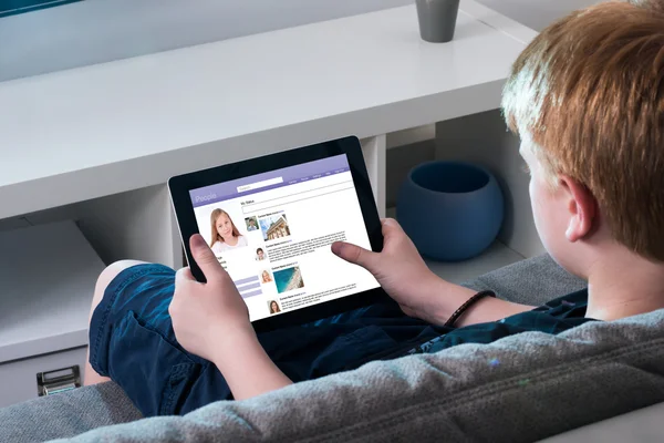 Boy Using Social Networking Site On Digital Tablet